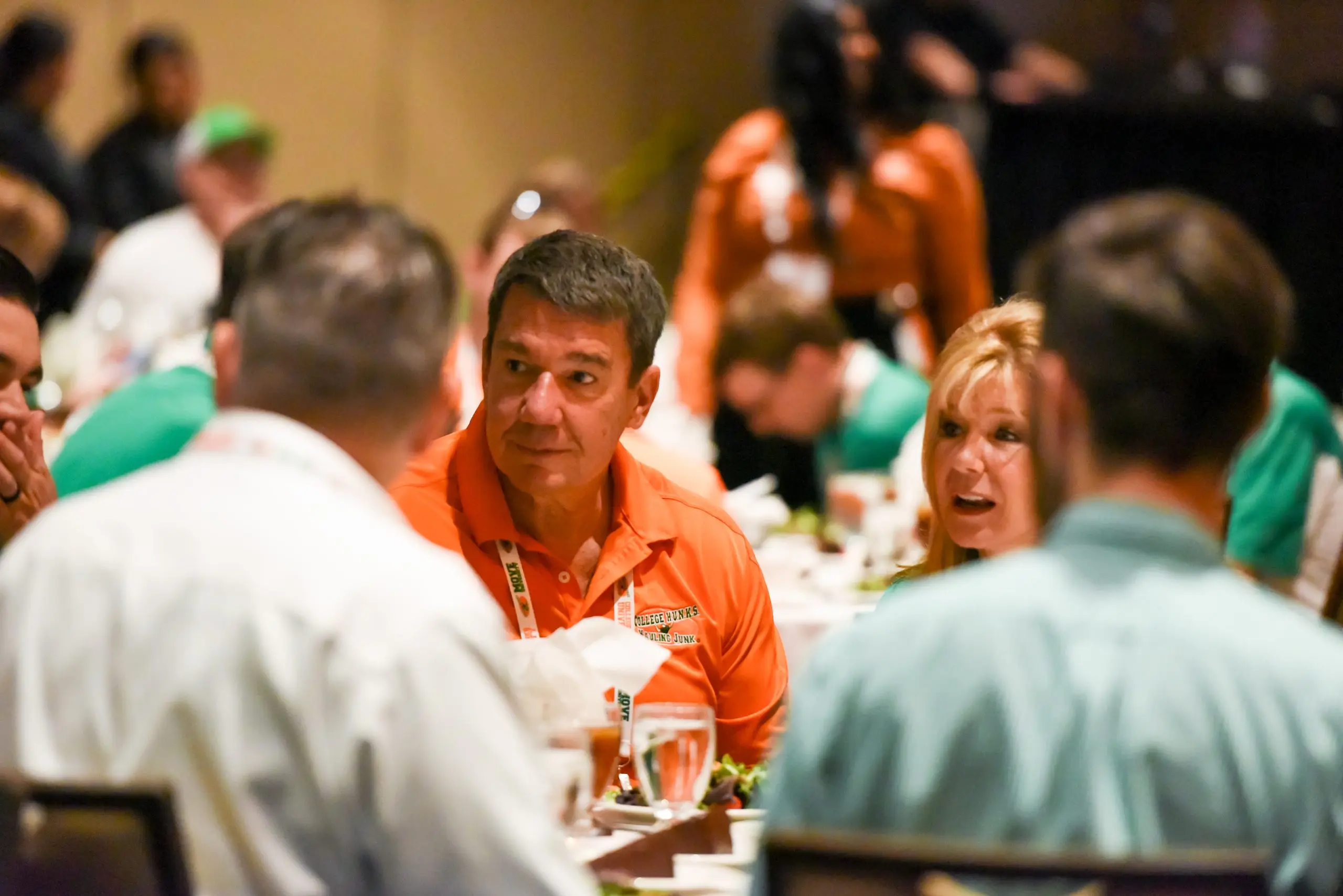 College HUNKS franchise owners in branded polos talking together at the brand's annual owner reunion