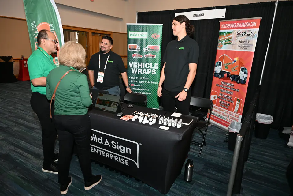 Franchise owners visiting a vendor booth at the College HUNKS conference expo