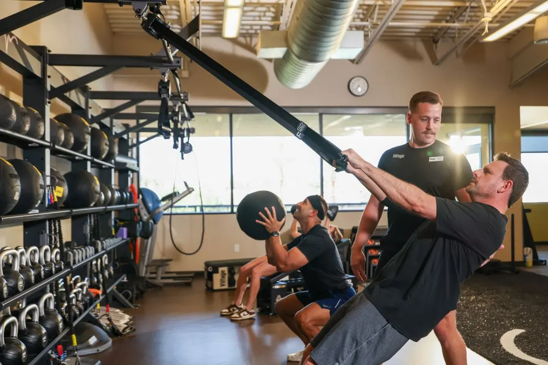 Village men training with straps and medicine ball