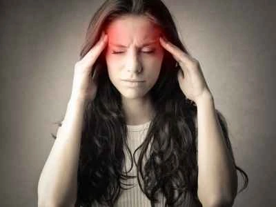 woman holding her temples while experiencing a headache with highlighted areas of head pain