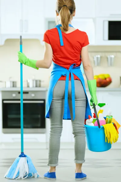 Maid standing in kitchen of Hutto, TX home getting ready to deep clean