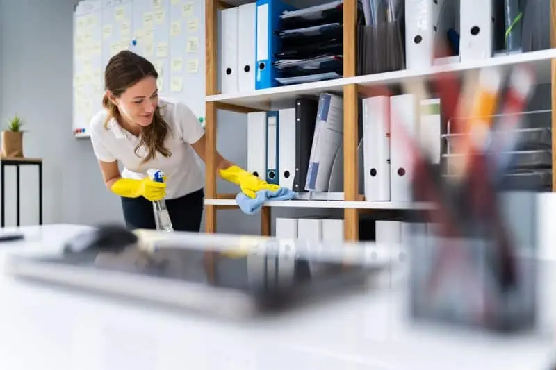 Commercial cleaner wiping down bookshelf