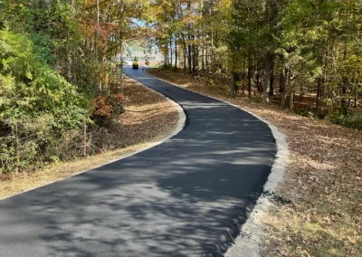 New asphalt walking trail winding through a wooded park