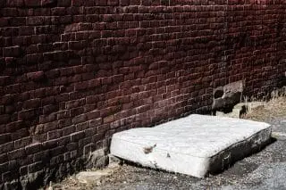 old and dirty mattress left on the side of the street