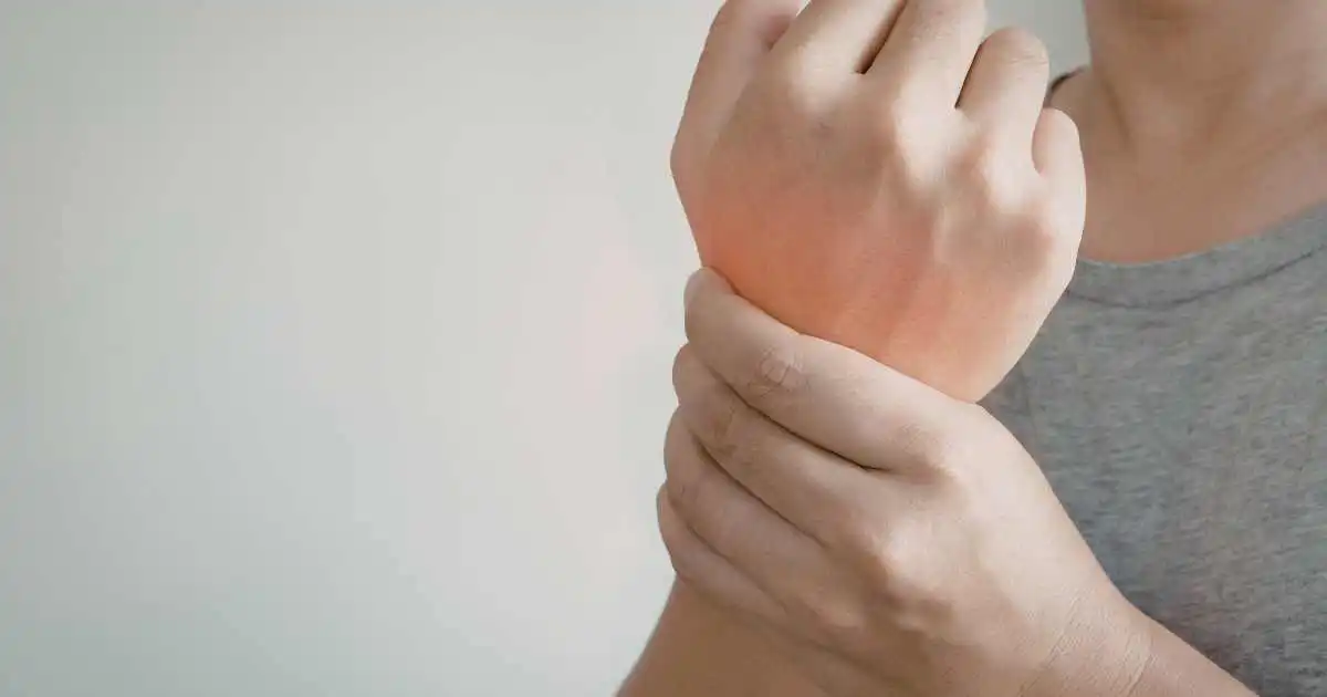 hand-nerve-compression-exam woman holding her wrist due to hand pain and nerve compression symptoms