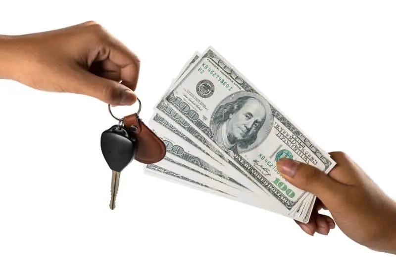 close up of people exchanging cash for car keys, purchasing a car
