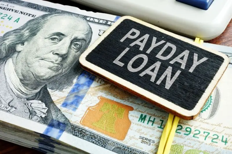payday loan sign sitting on stack of cash