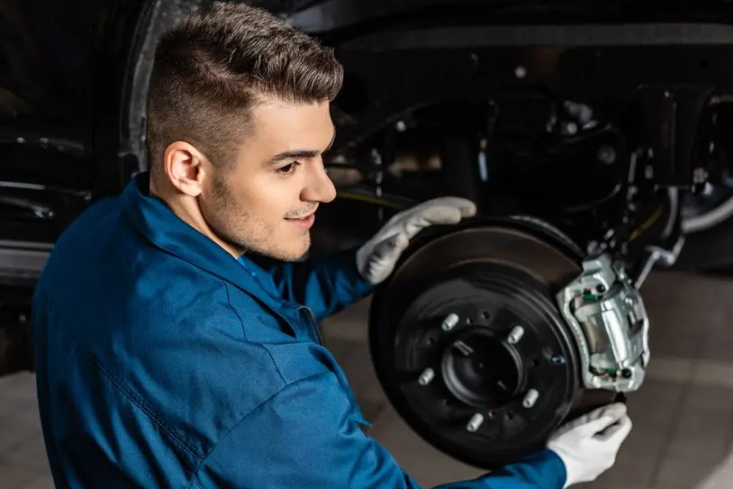 handsome mechanic adjusting assembled disc brakes with brake caliper