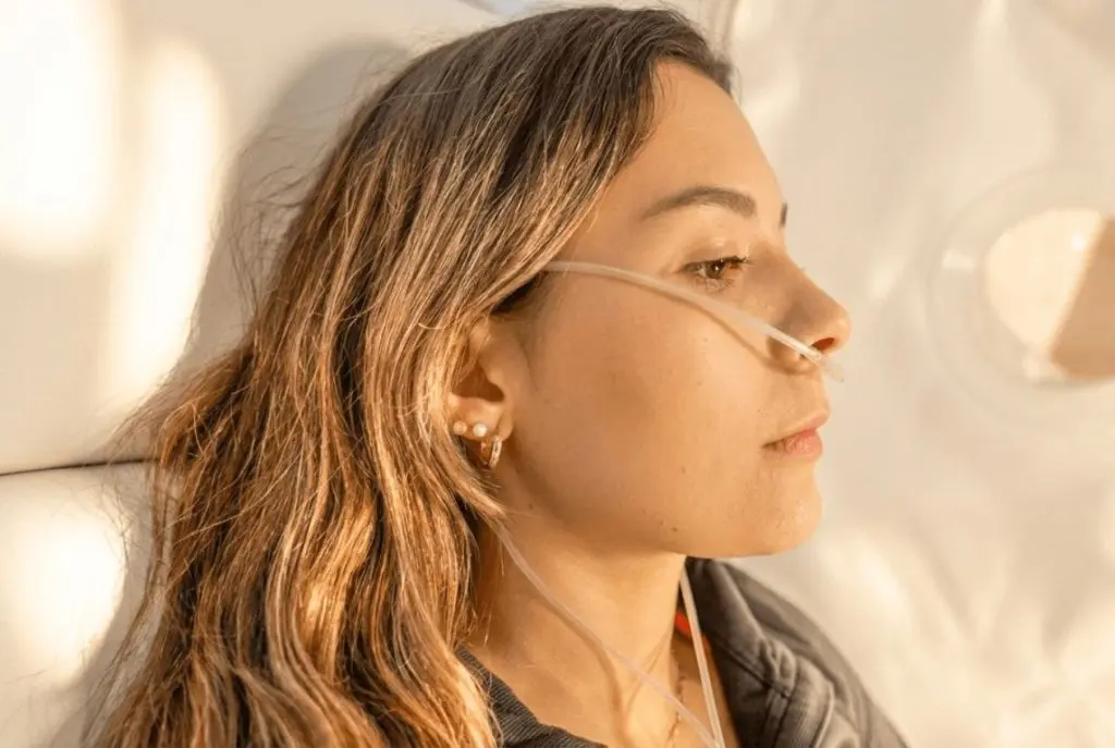 Close-up of a woman receiving oxygen through a nasal cannula during a hyperbaric oxygen therapy session for mental clarity and brain fog at SILA Miami, FL.