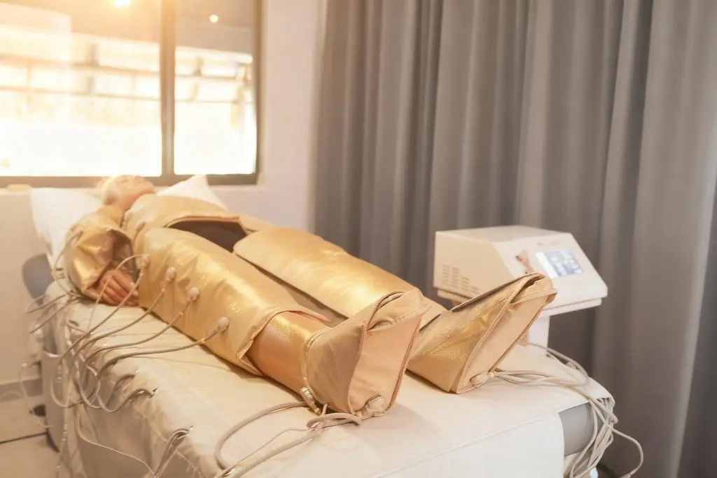 Woman relaxing in a lymphatic compression suit during a recovery session at SILA Miami
