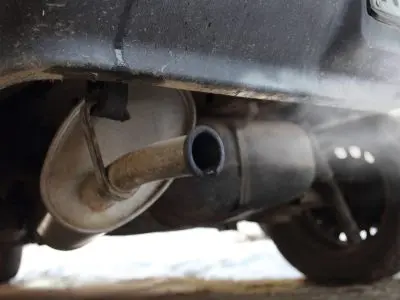 Close-up of a car exhaust pipe during a safety and emissions inspection and testing process.