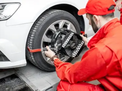 Auto mechanics making wheel alignment at the car service