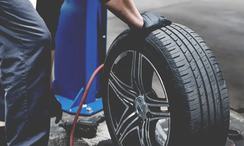 Tire Pressure Check Close Up of Gloved Hands and Tire at Spirit One Automotive Repair Shop in Benton Park West, St. Louis Missouri