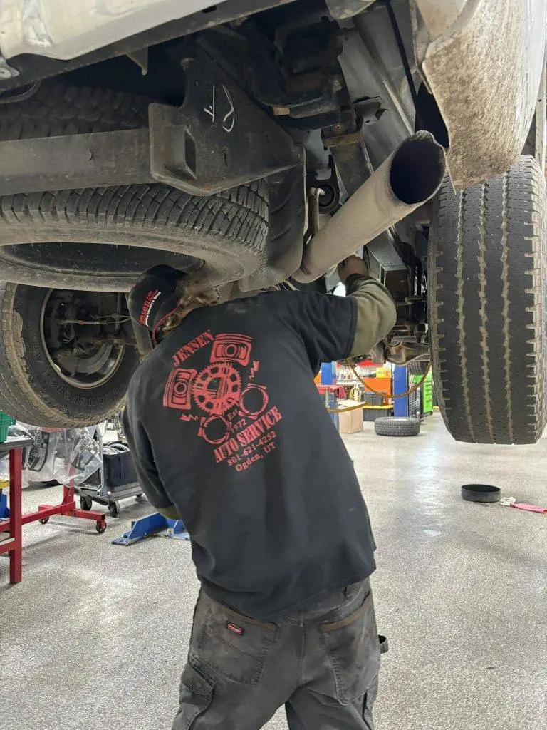 A mechanic fixing a exhaust