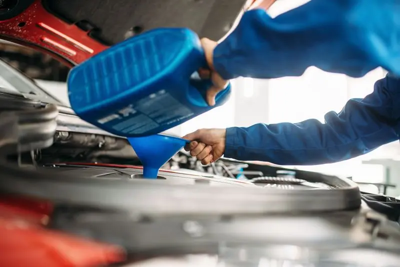 Technician change oil in the car engine