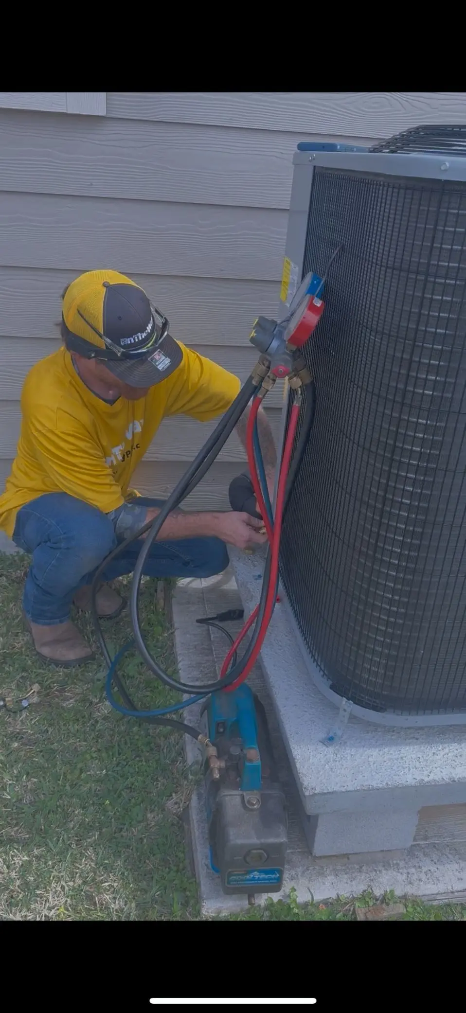 AC repair technician with manifold gauges at outdoor condenser unit