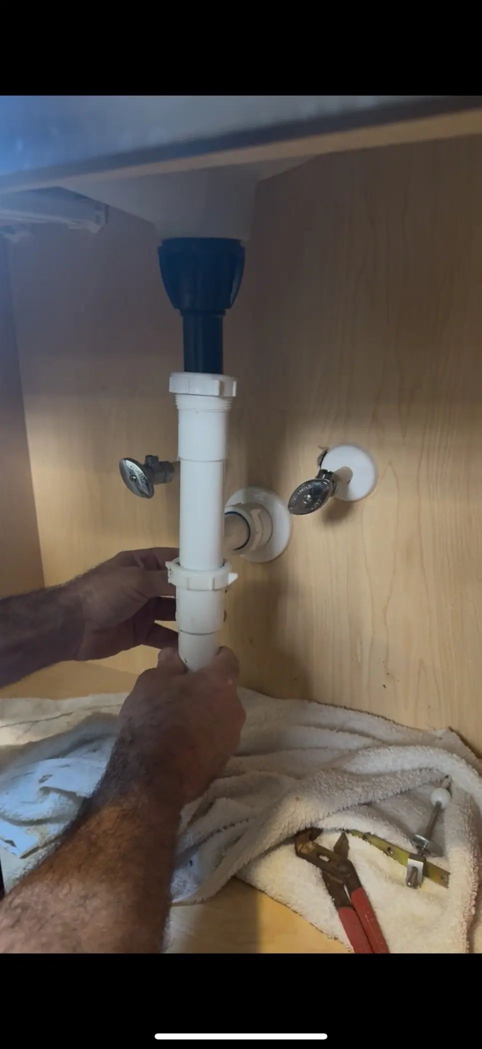 On The Way plumber installing drain trap under kitchen sink