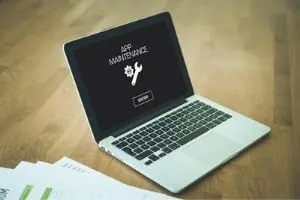 Laptop displaying "APP MAINTENANCE" message with a wrench icon, symbolizing technical updates or repairs relevant to plumbing service management.