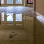 Indoor flooded floor reflecting the ceiling; highlights plumbing issues, relevant for B&L Plumbing maintenance tips.