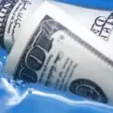 Dollars submerged in water, symbolizing the cost of water bills and the importance of water conservation for reducing expenses and environmental impact.