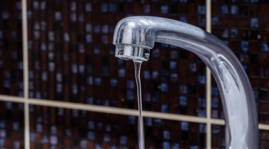 Chrome faucet with water flowing, representing plumbing issues related to low water pressure, relevant to B&L Plumbing services.