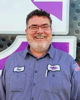 Rick Miller, smiling technician in work uniform with name tag, showcasing expertise in plumbing and HVAC services at B&L Plumbing and Heating.