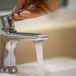 Chrome-plated faucet with clear water flowing, showcasing essential plumbing services by B&L Plumbing.