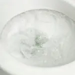 Clean toilet bowl filled with swirling, frothy water, emphasizing sanitation for homeowners seeking plumbing solutions.