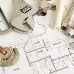 Tools including a wrench and compass on blueprints detailing plumbing and electrical systems for B&L Plumbing services.