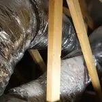 Ductwork installation with insulation and wooden support beams, relevant to air duct system maintenance and upgrades in HVAC services.
