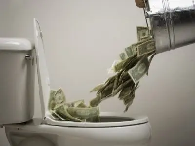 Money being poured into a toilet, symbolizing wasted resources and high water bills due to potential slab leaks.