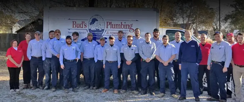 Group photo of Bud's Plumbing team, showcasing professional staff in uniforms, standing in front of company vehicle, emphasizing quality plumbing service and customer care in Evansville, IN.