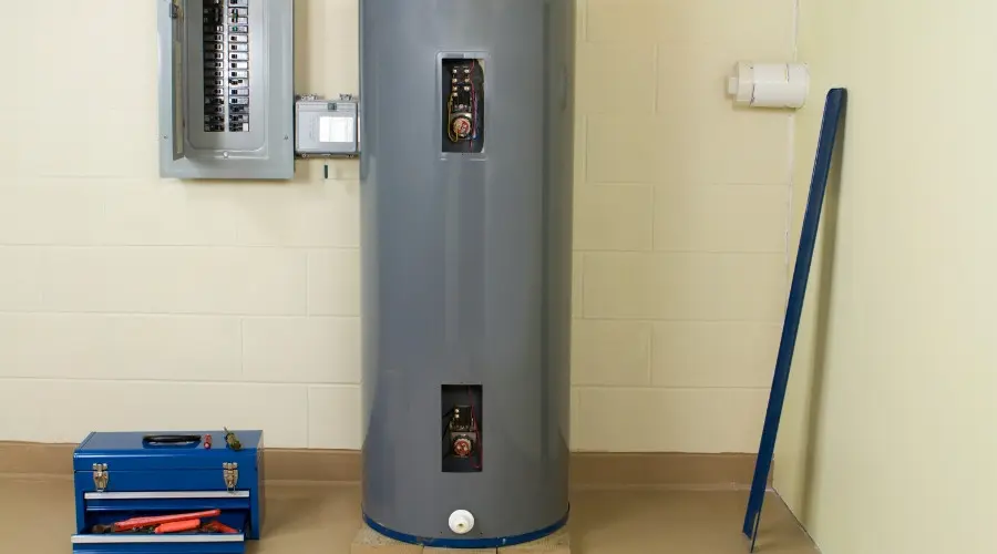 Water heater in a utility room with electrical panel, tools, and maintenance items, illustrating plumbing services related to hot water issues and replacement guidance.