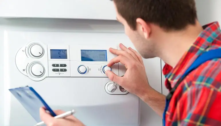 Technician adjusting settings on a non-condensing gas boiler control panel, emphasizing installation and repair services for energy-efficient heating solutions in Vancouver.