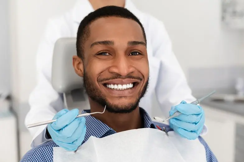 man.smiling.dental.chair