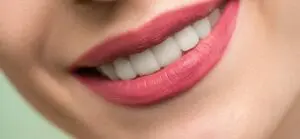 an image of a woman with pink lipstick smile after her procedure in big smile dental