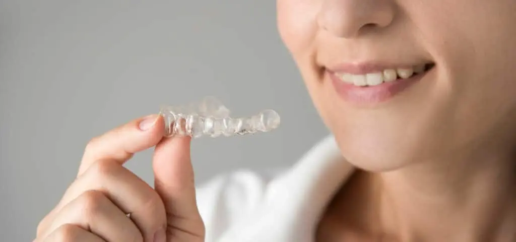 woman holding invisalign