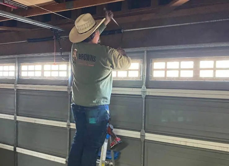 garage-spring-repair Expert technician adjusting high-tension springs during a garage door service call in the Central Valley.