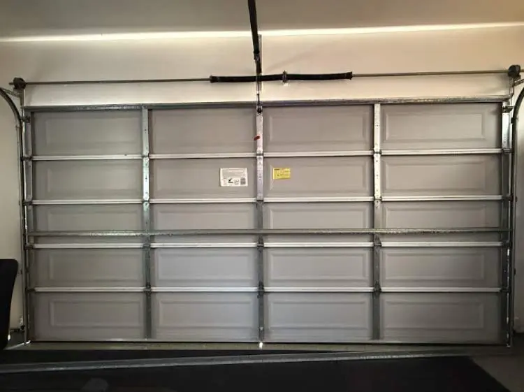 broken-garage-door Interior view of a garage door in need of a professional noisy garage door fix.