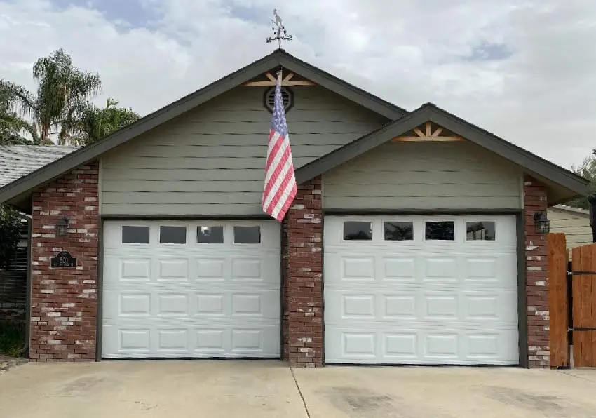 garage-and-usa-flag White raised-panel garage doors installed by Browns Garage Door on a home featuring an American flag.