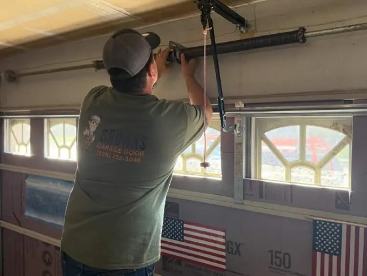 A Browns Garage Door technician performing a professional automatic garage door repair  spring on a residential torsion system.