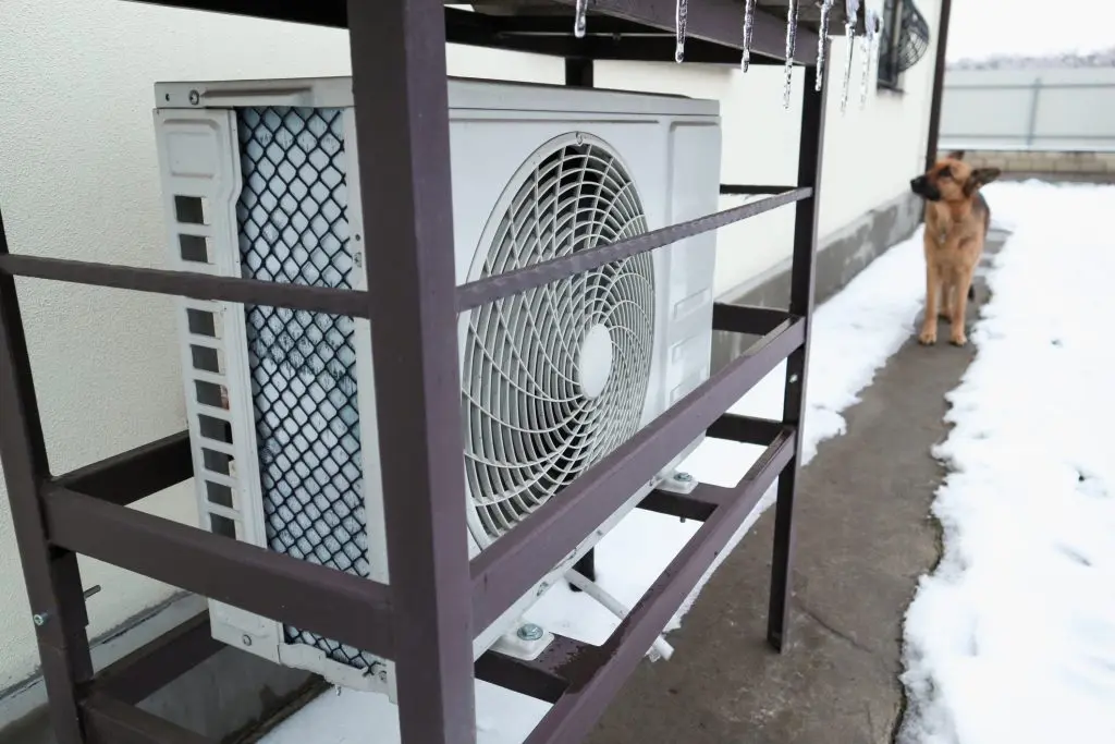 Heat pump outside home during winter