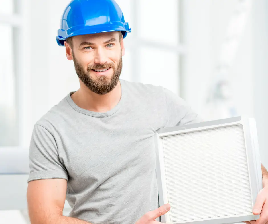 An HVAC technician holds a HEPA filter