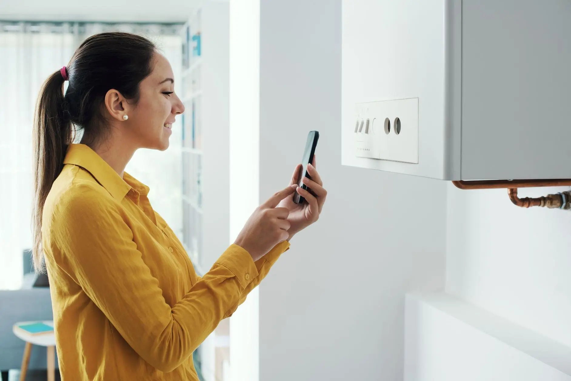 Woman managing her smart boiler using her phone