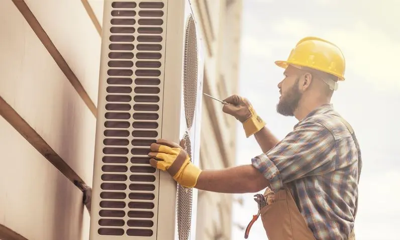 Male technician repairing air conditioner at home