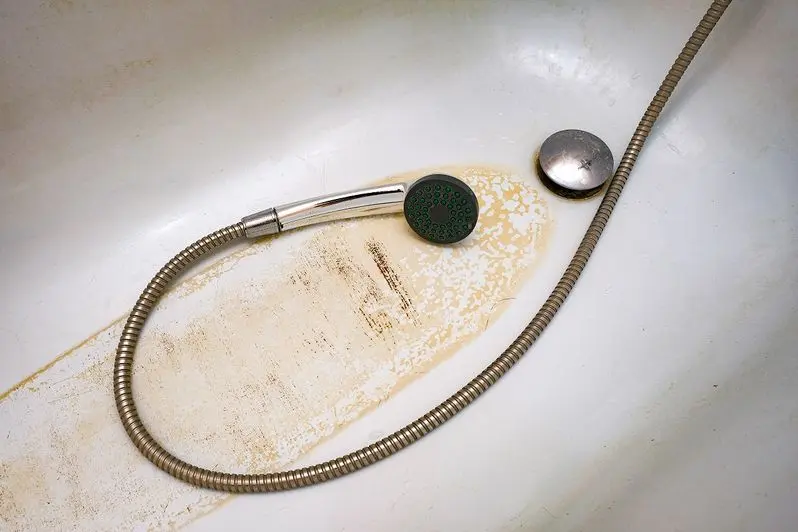 dirty bath drain mesh, hole and surface covered with limescale