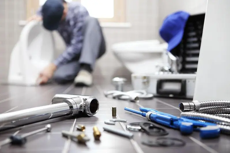 Plumber installing a new toilet with tools on the ground
