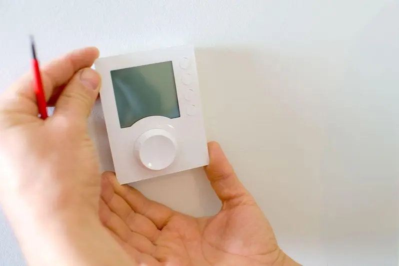 Electrician fitting a new thermostat