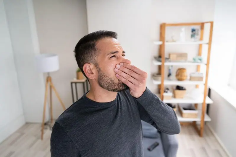 Man smelling something bad