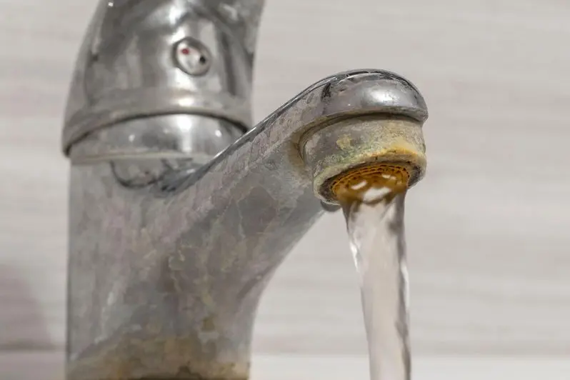 Hard water flows from an old tap aerator